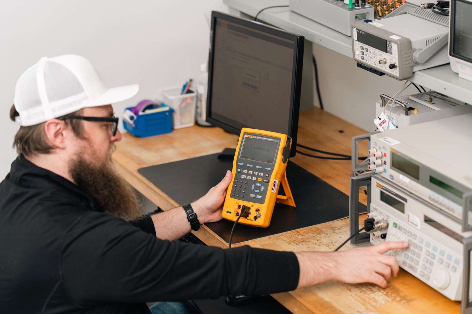 Technician calibrating with Fluke process calibrator at workstation